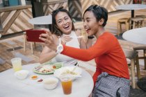 Jovem asiático feminino amigos tomando selfie no comida tribunal — Fotografia de Stock