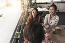 Group of friends at a restaurant, talking — Stock Photo