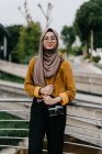 Молода азіатська мусульманка в хіджабі з камерою — стокове фото