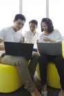 Giovani asiatici uomini d'affari che lavorano con i computer portatili in ufficio moderno — Foto stock