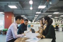 Jeunes gens d'affaires asiatiques sur la réunion dans le bureau moderne — Photo de stock