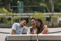 Gruppe von Freunden in einem Restaurant mit Blick aufs Telefon — Stockfoto