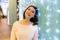 Молода приваблива азіатська жінка портрет біля гірлянди — стокове фото