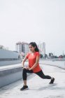 Young asian sporty woman doing exercise outdoors — Stock Photo