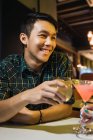 Молодой азиат с коктейлем в уютном баре — стоковое фото