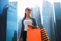 Junge schöne asiatische Frau mit Einkaufstüten in der Stadt — Stockfoto
