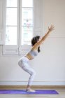 Giovane donna asiatica che fa esercizi su mat — Foto stock