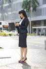 Asiático mujer de negocios chequeo teléfono - foto de stock