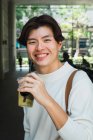 Retrato de sonriente asiático hombre celebración de bebidas - foto de stock