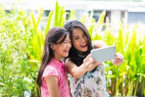 Happy asian mother and girl taking selfie — Stock Photo