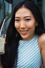 Retrato de sorrindo jovem asiático mulher com bebida — Fotografia de Stock