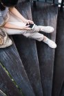 Молодая привлекательная азиатка сидит на ступеньках со смартфоном — стоковое фото