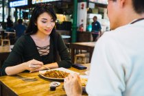 Junges asiatisches Paar isst Essen im Café — Stockfoto