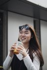 Chinesische Frau mit langen Haaren trinkt Saft — Stockfoto