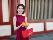 Chinese woman holding oranges — Stock Photo