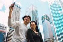 Jovem asiático casal tomando selfie no cidade rua — Fotografia de Stock