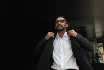 Молодий успішний бізнесмен струшуючи куртку — стокове фото