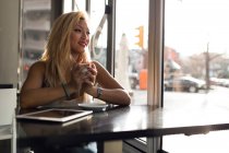 Retrato de bela jovem bebendo café em uma cafeteria . — Fotografia de Stock