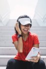 Молода азіатська спортивна жінка використовує навушники і розумний — стокове фото