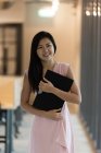 Молодая азиатская успешная предпринимательница с блокнотом в современном офисе — стоковое фото