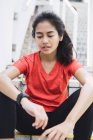 Junge asiatische sportliche Frau Kontrolle der Zeit auf Treppen — Stockfoto