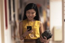 Счастливая молодая женщина с помощью смартфона — стоковое фото