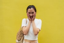 Portrait de jeune femme asiatique attrayante sur fond jaune — Photo de stock