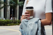 Imagen recortada de mujer joven con taza de café - foto de stock