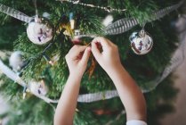 Asiatique famille célébrant Noël vacances, recadré image de garçon décoration sapin — Photo de stock