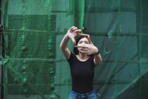 Молодая привлекательная азиатская девушка показывает рамку за пальцами на открытом воздухе — стоковое фото