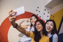 Jeunes femmes asiatiques prenant selfie dans bureau moderne créatif — Photo de stock