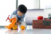 Carino poco asiatico ragazzo giocare con giocattoli — Foto stock