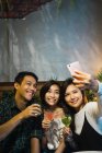 Jovem asiático amigos tomando selfie no confortável bar — Fotografia de Stock
