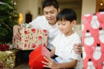 Happy asian family at christmas holidays, father and son holding presents — Stock Photo