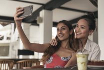 Femmes heureuses déjeuner et prendre selfie — Photo de stock