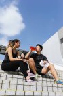 Felice asiatico sportivo coppia bere acqua su stadio — Foto stock