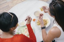 Jovem asiático feminino amigos comer comida no comida tribunal — Fotografia de Stock