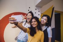 Jovem asiático mulheres tomando selfie no criativo moderno escritório — Fotografia de Stock