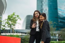 Giovani asiatiche donne d'affari utilizzando smartphone — Foto stock