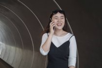 Китаянка с длинными волосами говорит по смартфону — стоковое фото