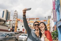 Joven asiático pareja pasando tiempo juntos y tomando selfie - foto de stock