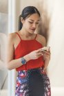 Молодая привлекательная азиатка с помощью смартфона — стоковое фото