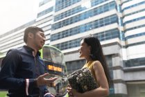 Feliz jovem asiático casal falando no ônibus parar — Fotografia de Stock
