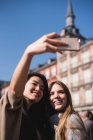 Chinês e europeu tirando uma selfie e sorrindo na Plaza Mayor, Madrid — Fotografia de Stock