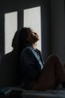 Giovane attraente asiatico donna seduta in ombre a stanza — Foto stock