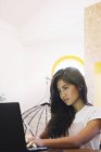 Jeune femme asiatique à l'aide d'un ordinateur portable dans un bureau moderne créatif — Photo de stock