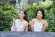 Duas mulheres malaias jovens surpresas e felizes ao ar livre — Fotografia de Stock