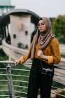 Junge asiatische Muslimin im Hijab posiert in der Nähe von Zaun — Stockfoto