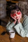 Jeune adulte asiatique femme en lunettes de soleil avec tasse de café — Photo de stock