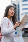 Junge Chinesin mit einer Landkarte in Barcelona — Stockfoto